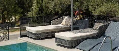 A swimming pool with lounge chairs and a canopy.