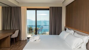 Una camera d'albergo con un letto, una scrivania e vista mare.