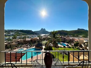 Un complexe hôtelier doté d’une piscine, de palmiers et offrant une vue sur une montagne en arrière-plan.