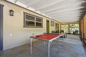 A covered outdoor area with a ping pong table, a window, and a door. - Gateway to the Sequoia's Home in Three Rivers Game room - Perfect for Groups (Three Rivers)