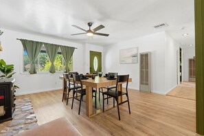 A dining area with a round table, chairs, a ceiling fan, and a view of the outdoors through a window with curtains. - Gateway to the Sequoia's Home in Three Rivers Game room - Perfect for Groups (Three Rivers)