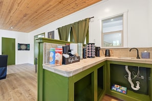 A kitchen area with a coffee bar, dartboard, and a window with curtains. - Gateway to the Sequoia's Home in Three Rivers Game room - Perfect for Groups (Three Rivers)