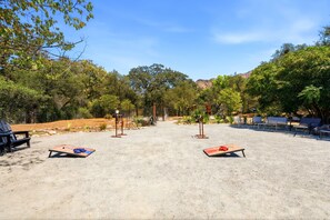 An outdoor area with two sun loungers, a fenced enclosure, and a variety of trees. - Gateway to the Sequoia's Home in Three Rivers Game room - Perfect for Groups (Three Rivers)