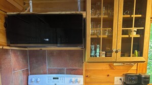A compact kitchen with a stove, oven, and a coffee maker on the counter.