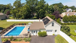 A residential property with a swimming pool, a covered patio, and a garage. - Saybrook Point Pool House (Old Saybrook)
