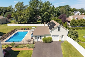 A residential property with a swimming pool, a covered patio, and a garage. - Saybrook Point Pool House (Old Saybrook)