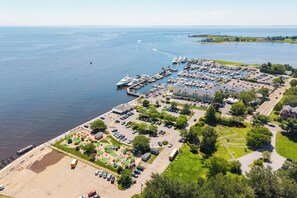 An aerial view of a marina with boats docked, a parking lot, and a golf course.
