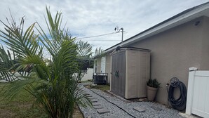 Un sendero conduce a un edificio con una fuente y una planta en maceta.