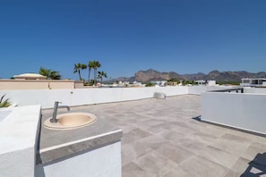 A rooftop terrace with a sink, a flat roof, and a view of mountains. - Modern home close to pickleball, beach, pool (La Manga)