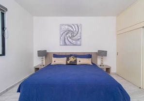 A bedroom with a large bed, two bedside tables, a wall-mounted artwork, and a wardrobe. - Modern home close to pickleball, beach, pool (La Manga)