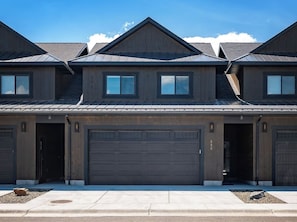 A row of residential buildings with multiple garage doors and a clear sky. - Stone Peak Mountain Retreat - New w/ ac (Driggs)