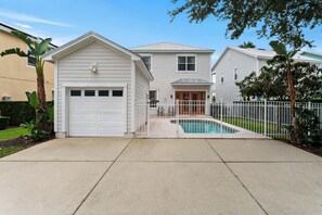 Ein Wohnhaus mit Garage, Eingangstür, Schwimmbad und umzäunter Garten.