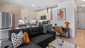Un appartement moderne comprenant un espace de vie, une kitchenette et un coin repas.