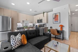 A modern apartment with a living area, kitchenette, and a dining space. - Stylish 1 King BR suite-Domain Gym, Pool & Parking (Austin)