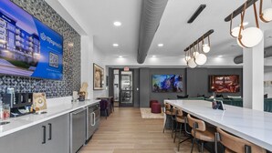 Une cuisine moderne dotée d’un coin bar, d’un espace dédié au café et d’un coin repas avec des tabourets de bar.