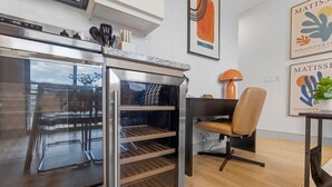 Eine moderne Küche mit Backofen, ein Essbereich mit einem Stuhl und Kunstwerken an der Wand.