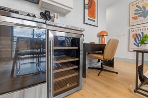 Eine moderne Küche mit Backofen, ein Essbereich mit einem Stuhl und Kunstwerken an der Wand.
