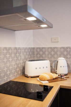 A kitchen with a toaster, a kettle, and a bread roll on the counter. - Donnybrook Cottages - Donnybrook (Clare)