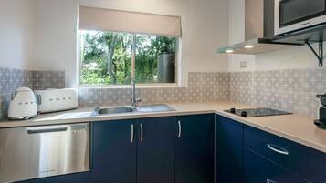 A modern kitchen with a built-in dishwasher, a double sink, and a microwave.
