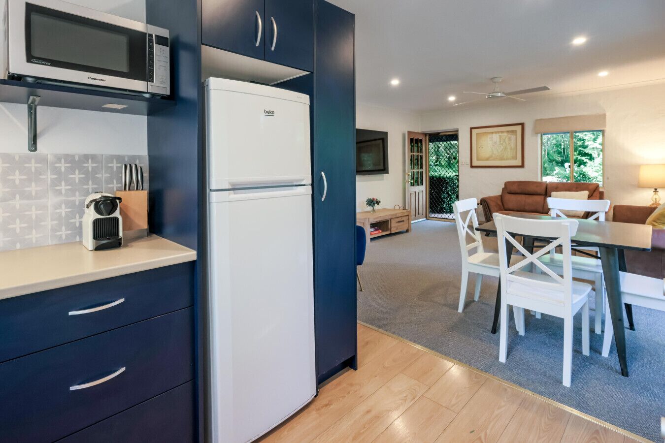 A compact kitchen with a microwave, refrigerator, and a coffee maker on the counter.