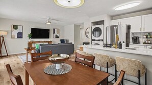 A modern kitchen with a central island, white cabinetry, and a built-in oven.