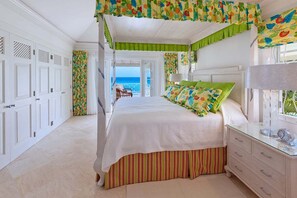 A bedroom with a bed, a dresser, and a view of the ocean. - Stylish Beachfront Villa with Plunge Pool - Still Fathoms (3 bed) (Reeds Bay)