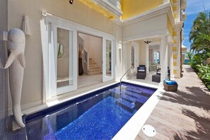 A pool area with a clear blue pool, a stone sculpture, and a pathway leading to a covered seating area. - Stylish Beachfront Villa with Plunge Pool - Still Fathoms (3 bed) (Reeds Bay)