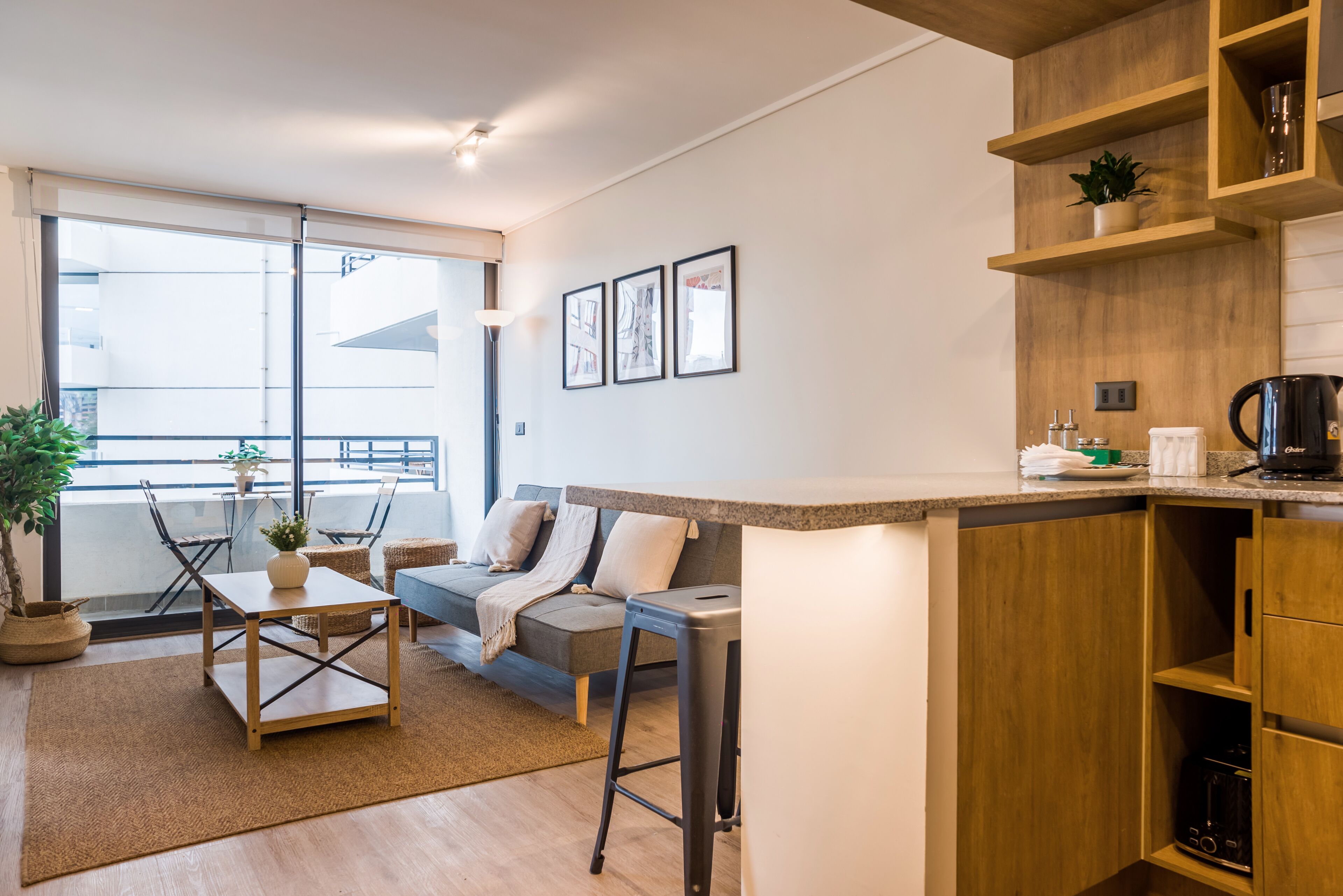 A modern apartment with a kitchen, dining area, and a balcony with a view.