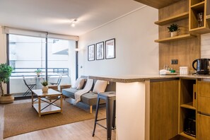 En moderne lejlighed med et køkken, spiseområde og en balkon med udsigt.