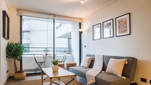 Un salon moderne avec un canapé gris, une table basse en bois et une plante en pot.
