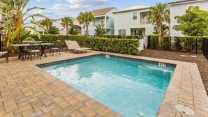 A swimming pool with a brick patio, lounge chairs, and a table. - Cozy 2-bedroom house 10 minutes to Disney! (Kissimmee)