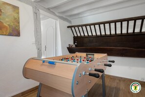 Ein Holztischkicker in einem Raum mit weißen Wänden und einer Holzbank.