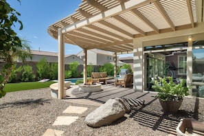 A covered patio with outdoor furniture, a grill, and a pool in the background. - Luxury Gilbert + Game Room/Fire Pit*Heated Pool (Gilbert)