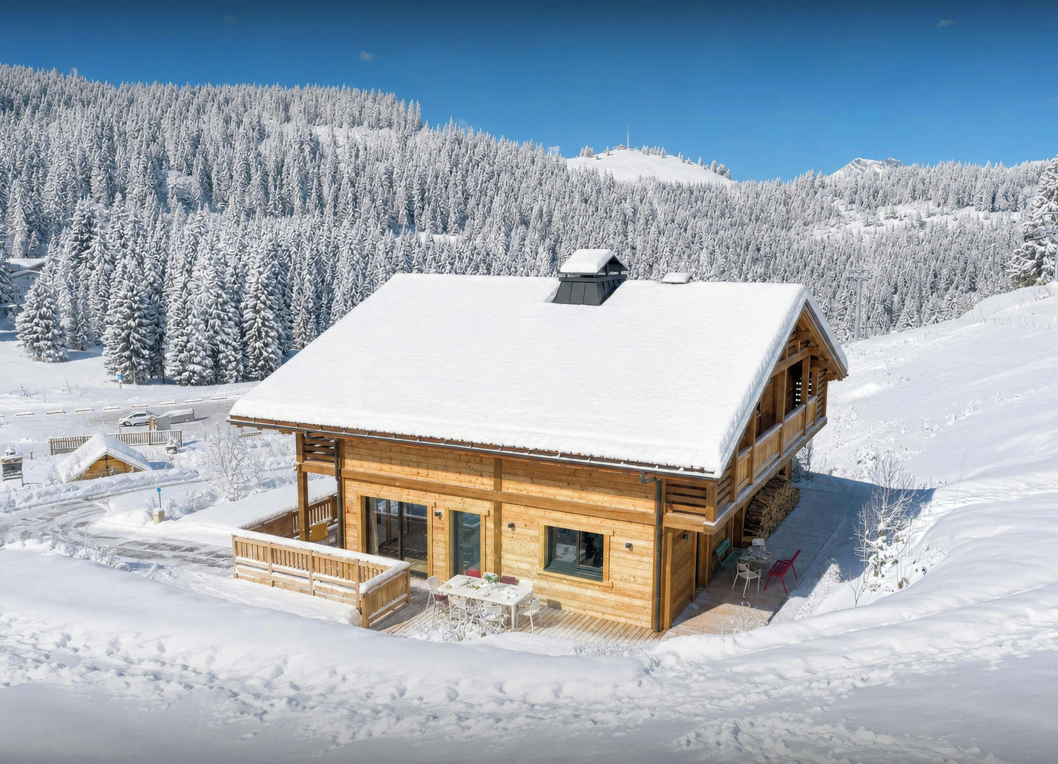 A wooden cabin with a snow-covered roof, surrounded by a snowy landscape and dense forest.