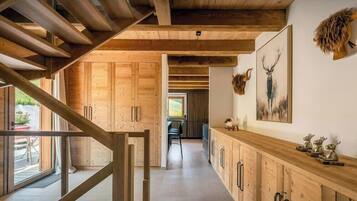 Un interior moderno con vigas de madera, una zona de cocina y cuernos de animales colgados.