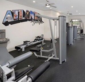 A gym with various exercise equipment, a water dispenser, and a wall sign that reads 'ATLANTIS Georgia'. - Elegant Atlanta Suite-FREE Parking, Ideal For Long Stays! (Atlanta)