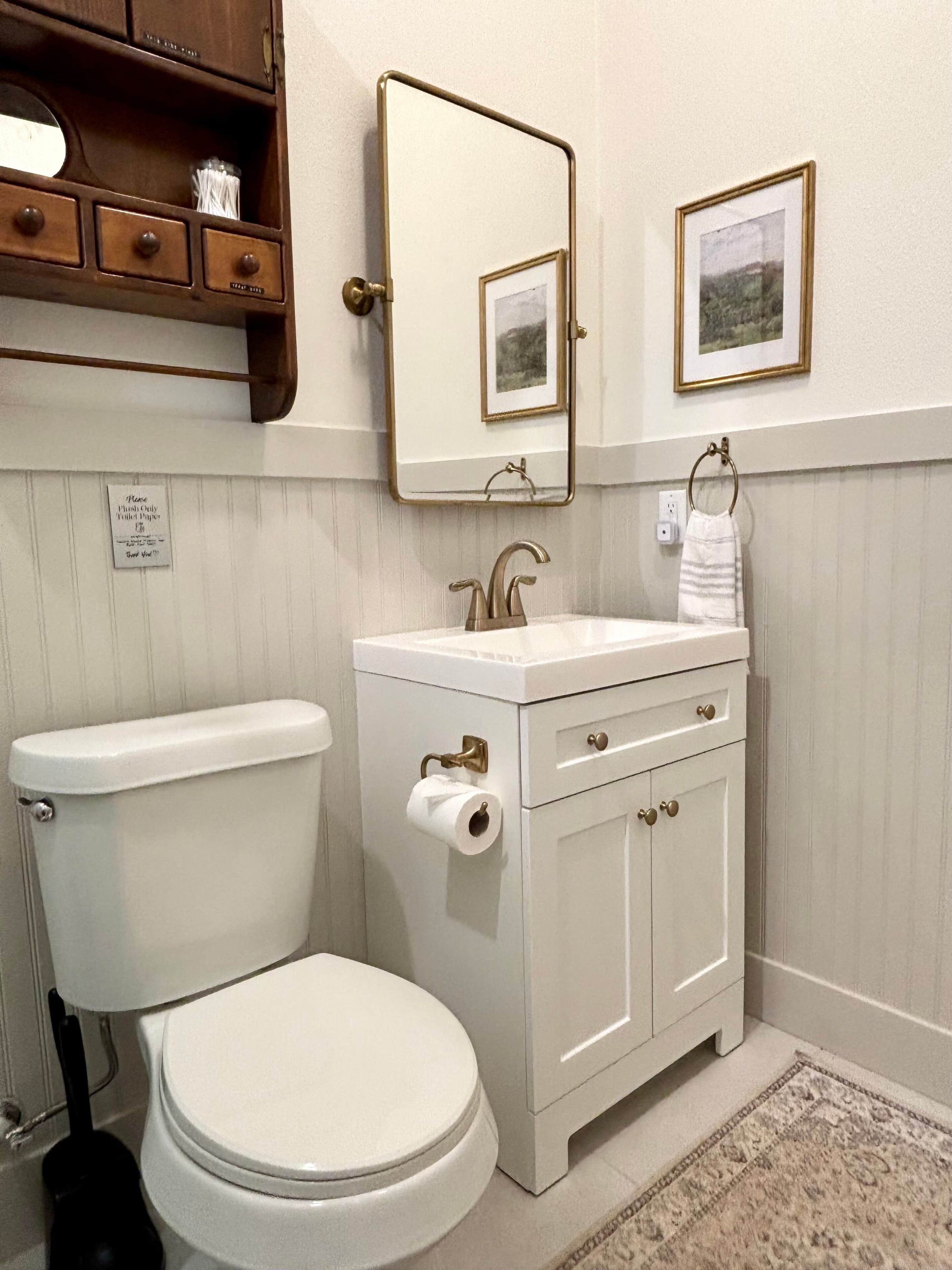Une salle de bain standard équipée de toilettes, d’un lavabo et d’un miroir.