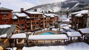 A resort with multiple buildings, a swimming pool, and snow-covered surroundings.