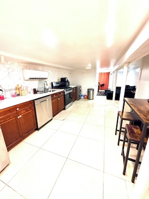 A modern kitchen with a central island, built-in oven, and stainless steel appliances. - StarBase Apartment (brooklyn)