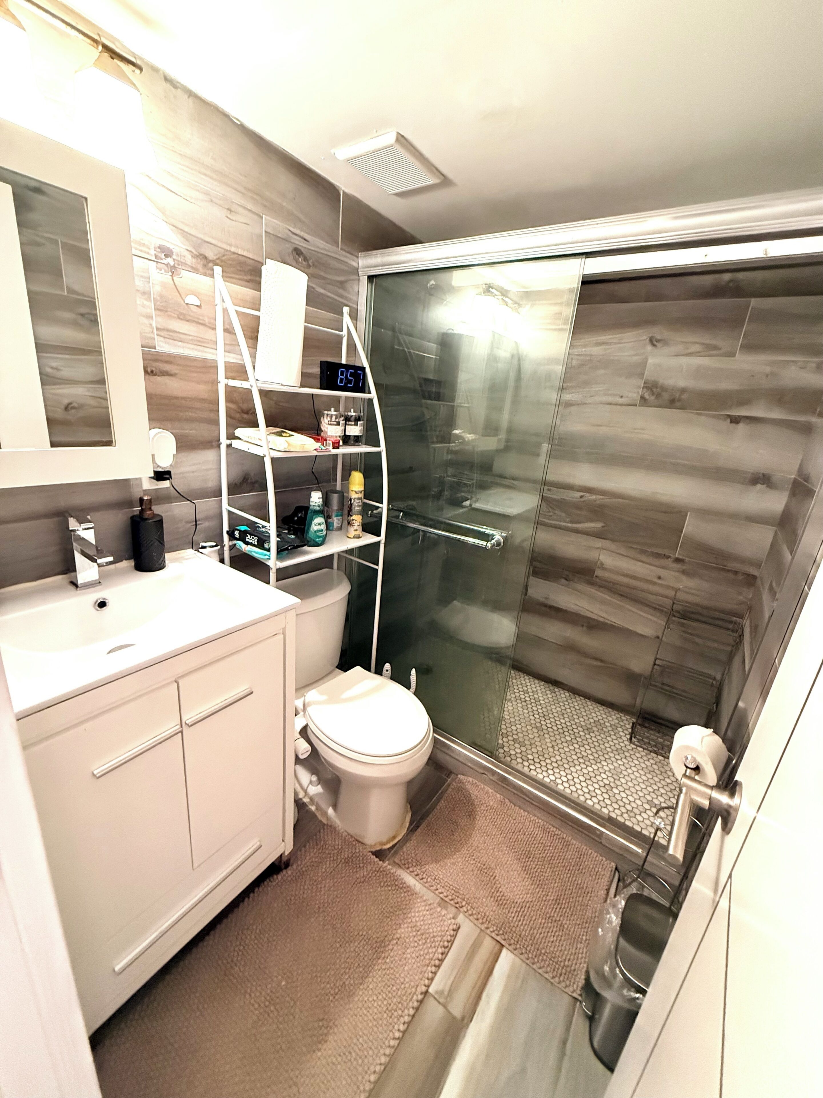 A modern bathroom with a toilet, sink, and a glass-enclosed shower area.