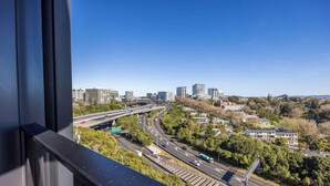 Stadsgezicht met snelweg, gebouwen en groen.