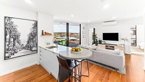 A modern apartment with a kitchen, dining area, and living room.