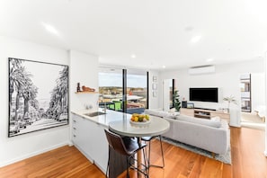 A modern apartment with a kitchen, dining area, and living room.