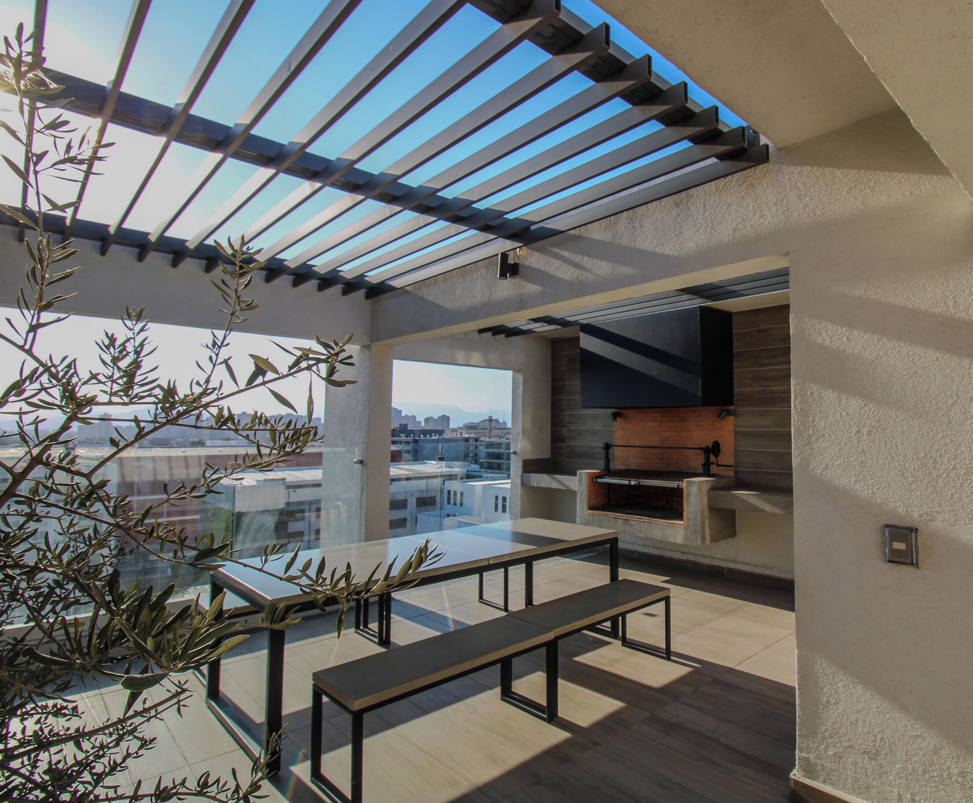 Un patio al aire libre con una pérgola, asientos y vistas de la ciudad.