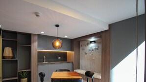 Uma cozinha moderna com uma mesa de jantar de madeira, cadeiras e uma luminária pendente.