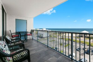 A balcony with wicker furniture, a view of the beach, and a parking area. - Stunning 2 BR Condo - Bring your Boat to the Beach - GSSR 709A (Gulf Shores)
