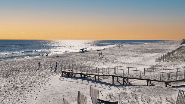 A beach with a wooden boardwalk leading to the water, sandy terrain, and a clear sky. - Stunning 2 BR Condo - Bring your Boat to the Beach - GSSR 709A (Gulf Shores)