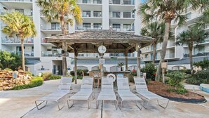 A poolside area with lounge chairs, a wooden gazebo, and a clock. - Stunning 2 BR Condo - Bring your Boat to the Beach - GSSR 709A (Gulf Shores)