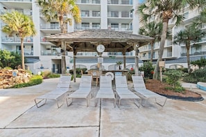 A poolside area with lounge chairs, a wooden gazebo, and a clock. - Stunning 2 BR Condo - Bring your Boat to the Beach - GSSR 709A (Gulf Shores)