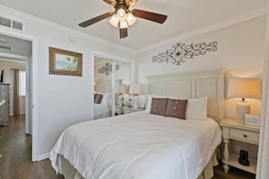 A bedroom with a bed, bedside table, lamp, ceiling fan, and a mirror. - Stunning 2 BR Condo - Bring your Boat to the Beach - GSSR 709A (Gulf Shores)